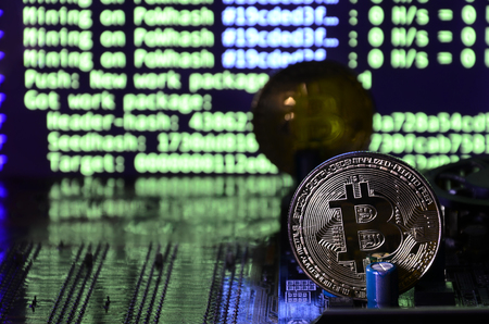The digital process of cryptocurrency mining by using the GPUs. Bitcoins and video card on a working display and mining screenの写真素材