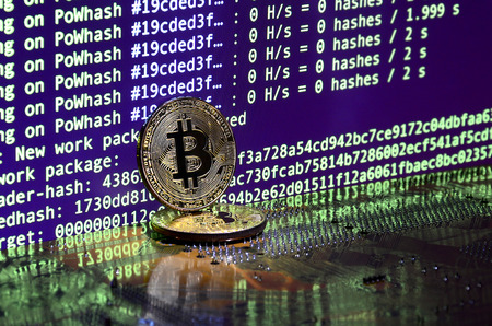 The digital process of cryptocurrency mining by using the GPUs. Bitcoins and video card on a working display and mining screenの写真素材