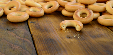 A lot of fresh yellow bagels lie on the surface of the old dark wood. A popular kind of flour products. One of the traditional Russian treats for teaの写真素材