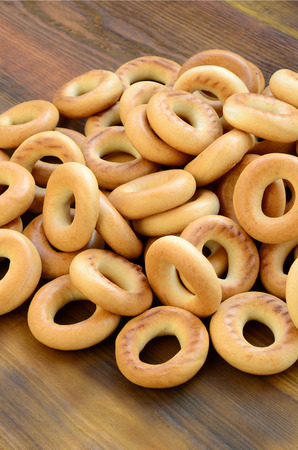 A lot of fresh yellow bagels lie on the surface of the old dark wood. A popular kind of flour products. One of the traditional Russian treats for teaの写真素材