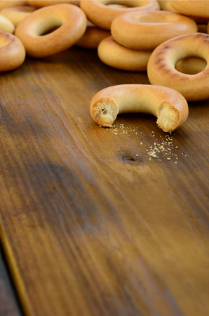 A lot of fresh yellow bagels lie on the surface of the old dark wood. A popular kind of flour products. One of the traditional Russian treats for teaの写真素材