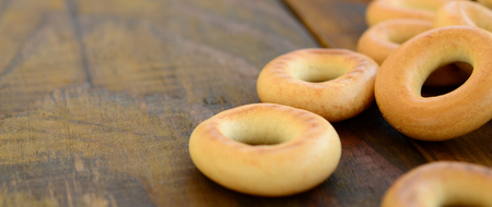 A lot of fresh yellow bagels lie on the surface of the old dark wood. A popular kind of flour products. One of the traditional Russian treats for teaの写真素材
