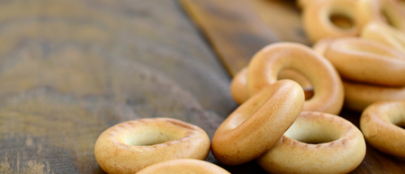 A lot of fresh yellow bagels lie on the surface of the old dark wood. A popular kind of flour products. One of the traditional Russian treats for teaの写真素材