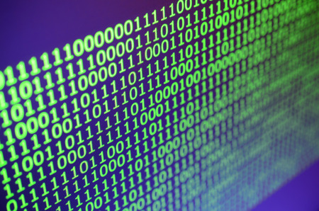 Macro shot of binary code on the monitor of an office computer. The concept of the programmer's...