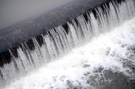 A picture of the flowing water. The dam is designed to regulate the water level in rivers within the city and to provide technical water to industrial objectsの写真素材