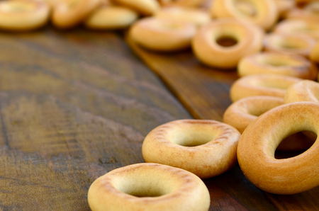 A lot of fresh yellow bagels lie on the surface of the old dark wood. A popular kind of flour products. One of the traditional Russian treats for teaの写真素材