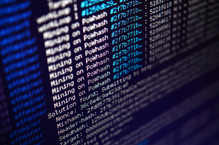 Macro snapshot of the program interface for crypto currency mining on the monitor of an office computer. The concept of mining bitcoins. The flow of information strings and dataの写真素材