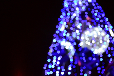 Blurred fragment of the New Year tree. Lots of round lights in blueの写真素材