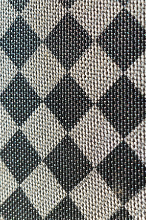 Plastic texture in the form of a very small cloth binding, painted in black and gray in the style of a chessboard. Macro shotの写真素材