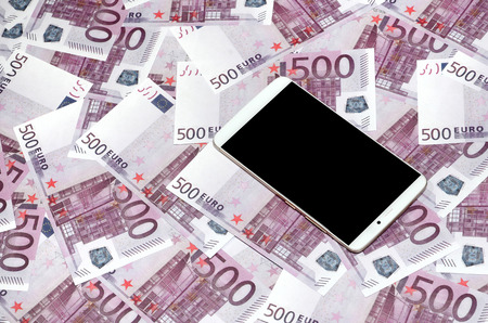 Purple 500 euro money bills and a smartphone with black screen. Copy space. The concept of online banking, money management and shopping with modern technologyの写真素材