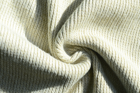 Fabric texture of a soft yellow knitted sweater. Macro image of the structure of bindings in yarnsの写真素材