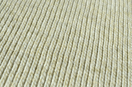 Fabric texture of a soft yellow knitted sweater. Macro image of the structure of bindings in yarnsの写真素材