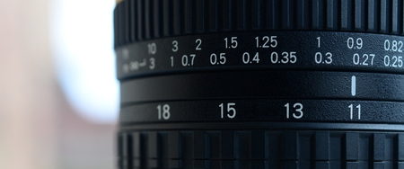 Fragment of a wide angle zoom lens for a modern SLR camera. The set of distance values is indicated by white numbers on the black bodyの写真素材
