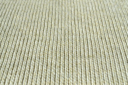 Fabric texture of a soft yellow knitted sweater. Macro image of the structure of bindings in yarnsの写真素材