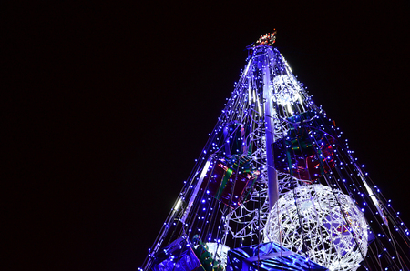Fragment of the New Year tree. A lot of round lights of blue color are located on a conical frameの写真素材