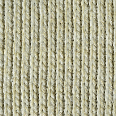 Fabric texture of a soft yellow knitted sweater. Macro image of the structure of bindings in yarnsの写真素材