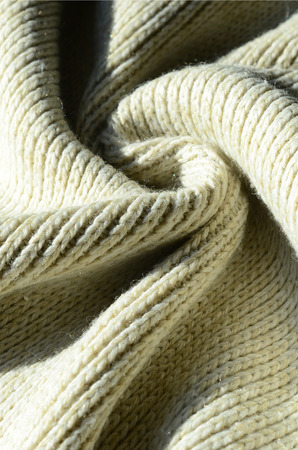 Fabric texture of a soft yellow knitted sweater. Macro image of the structure of bindings in yarnsの写真素材