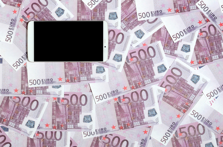 Purple 500 euro money bills and a smartphone with black screen. Copy space. The concept of online banking, money management and shopping with modern technologyの写真素材