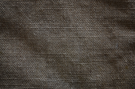 The texture of a very old brown sack cloth. Retro texture with canvas material. Background image with copy spaceの写真素材