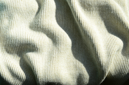 Fabric texture of a soft yellow knitted sweater. Macro image of the structure of bindings in yarnsの写真素材