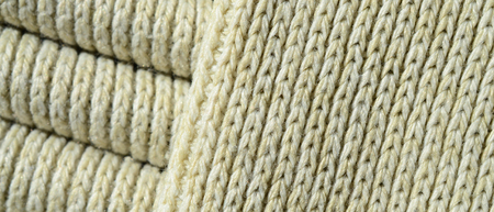 Composition of a soft yellow knitted sweater. Macro texture of bindings in yarnsの写真素材