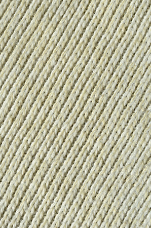 Fabric texture of a soft yellow knitted sweater. Macro image of the structure of bindings in yarnsの写真素材