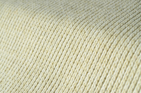 Fabric texture of a soft yellow knitted sweater. Macro image of the structure of bindings in yarnsの写真素材