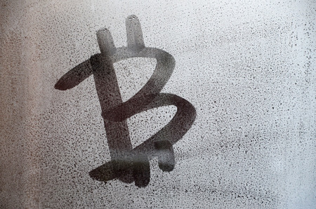 The bitcoin symbol on the misted sweaty glass. Abstract background image. Cryptocurrency conceptの写真素材
