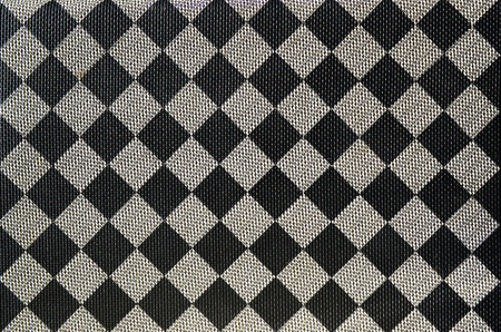 Plastic texture in the form of a very small cloth binding, painted in black and gray in the style of a chessboard. Macro shotの写真素材
