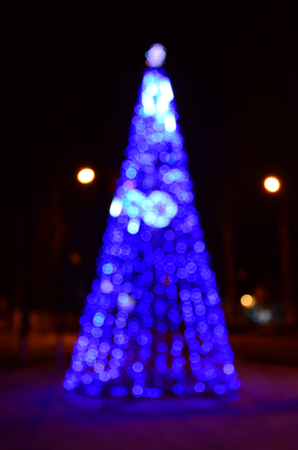Blurred photo of the New Year tree. Lots of round lights in blueの写真素材