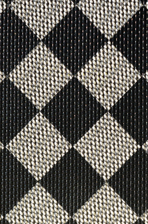 Plastic texture in the form of a very small cloth binding, painted in black and gray in the style of a chessboard. Macro shotの写真素材