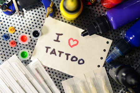 I love tattoo. The text is written on a small sheet of paper among various equipment for tattooingの写真素材