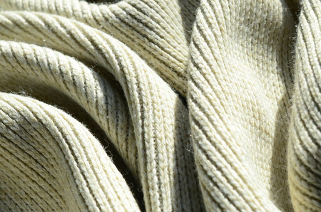 Fabric texture of a soft yellow knitted sweater. Macro image of the structure of bindings in yarnsの写真素材