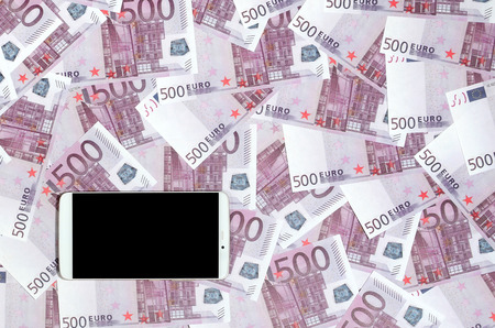 Purple 500 euro money bills and a smartphone with black screen. Copy space. The concept of online banking, money management and shopping with modern technologyの写真素材