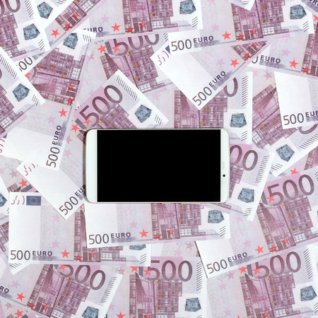 Purple 500 euro money bills and a smartphone with black screen. Copy space. The concept of online banking, money management and shopping with modern technologyの写真素材