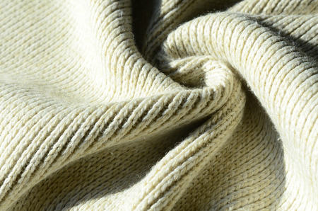 Fabric texture of a soft yellow knitted sweater. Macro image of the structure of bindings in yarnsの写真素材