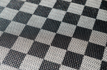 Plastic texture in the form of a very small cloth binding, painted in black and gray in the style of a chessboard. Macro shotの写真素材