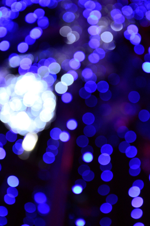 Blurred fragment of the New Year tree. Lots of round lights in blueの写真素材