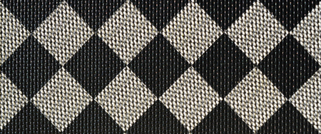 Plastic texture in the form of a very small cloth binding, painted in black and gray in the style of a chessboard. Macro shotの写真素材