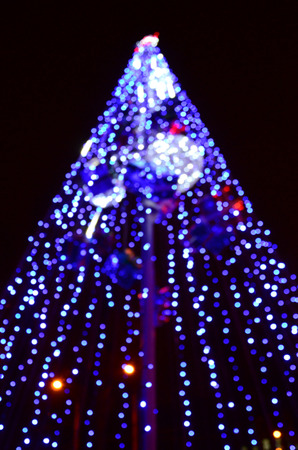 Blurred fragment of the New Year tree. Lots of round lights in blueの写真素材