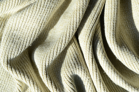 Fabric texture of a soft yellow knitted sweater. Macro image of the structure of bindings in yarnsの写真素材