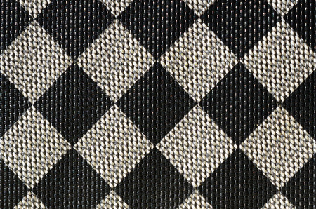 Plastic texture in the form of a very small cloth binding, painted in black and gray in the style of a chessboard. Macro shotの写真素材