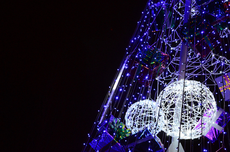 Fragment of the New Year tree. A lot of round lights of blue color are located on a conical frameの写真素材
