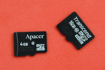 KHARKOV, UKRAINE - DECEMBER 29, 2017: Two small micro SD memory cards Apacer 4gb and Transcend 16gb lies on a red background. Illustrative editorialのeditorial素材