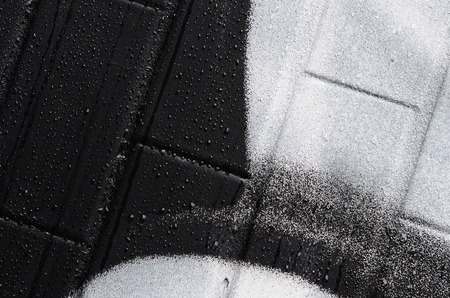 A fragment of a graffiti pattern, applied to a wall of cold tiles, which is covered with a fine condensate. The concept of street art in inappropriate weatherの写真素材