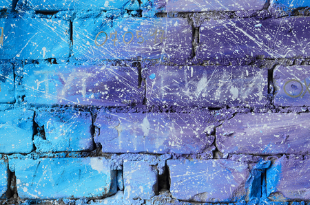 The texture of the old brick wall, painted in blue and purple colors with carelessly spaced white drops and splashes that visualize the stars in outer spaceの写真素材