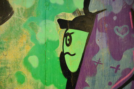 The old wall, painted in color graffiti drawing green aerosol paints. Background image on the theme of drawing graffiti and street artの写真素材