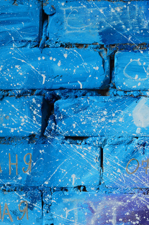 The texture of the old brick wall, painted in blue and purple colors with carelessly spaced white drops and splashes that visualize the stars in outer spaceの写真素材