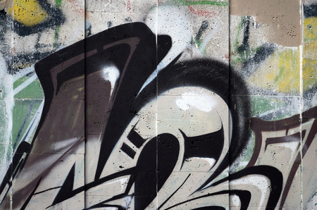 A fragment of detailed graffiti of a drawing made with aerosol paints on a wall of concrete tiles. Background image of street art in brown and cream tonesのeditorial素材