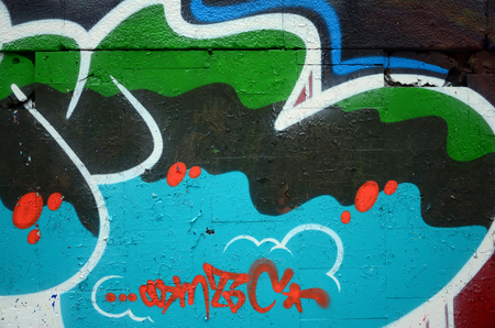 A fragment of graffiti drawing using contours, applied to the wall with the help of cans with aerosol paints over the colored filling areas. Background texture of street art and vandalismの写真素材